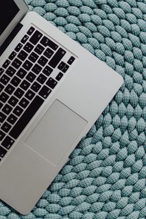 蓝色口袋上的MacBook笔记本电脑