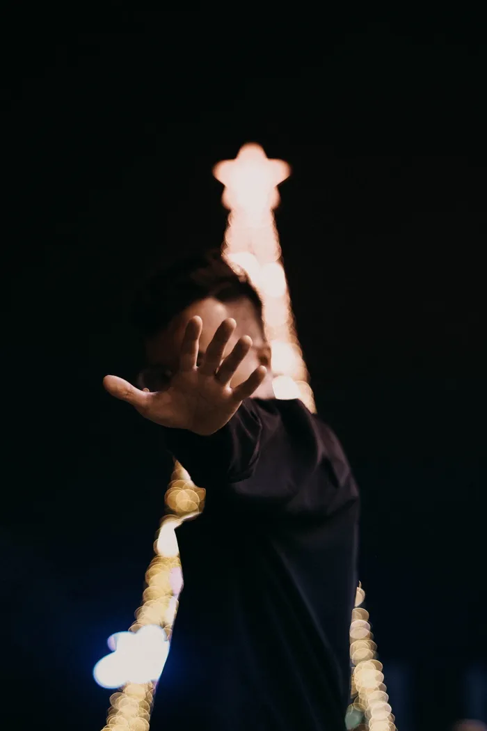 圣诞树旁穿着黑色运动衫的人