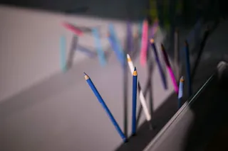 铅笔和蜡笔从墙上和地板上伸出来