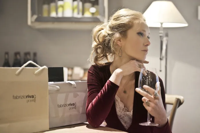 拿着酒杯的紫色和粉红色上衣的女人