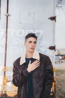 男子站立并用左手触摸胸部