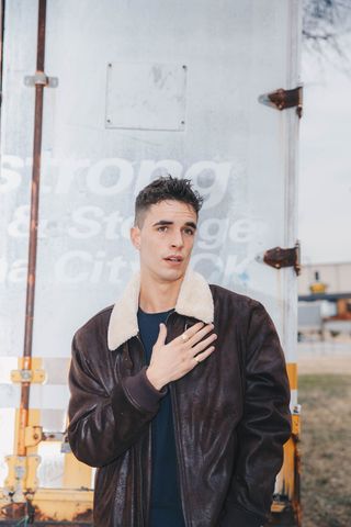 男子站立并用左手触摸胸部