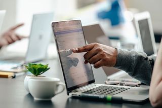 男子指着笔记本电脑屏幕拍照