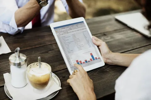 图表上使用银色Ipad的人 图表上使用银色Ipad的人