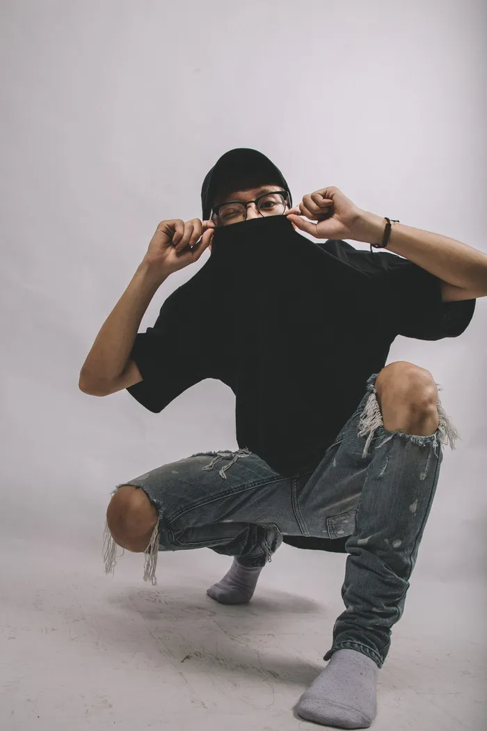 Man in Black Crew-neck Shirt and Blue Distressed Jeans Wearing Eyeglasses