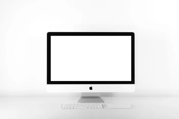 银色iMac，白色屏幕上配有苹果魔术键盘