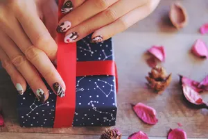 手持蓝色星座印刷礼盒的人