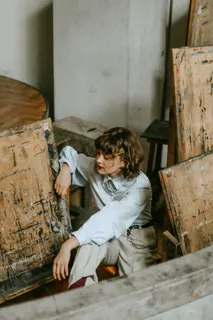 一名女子坐在画架旁摆姿势的照片