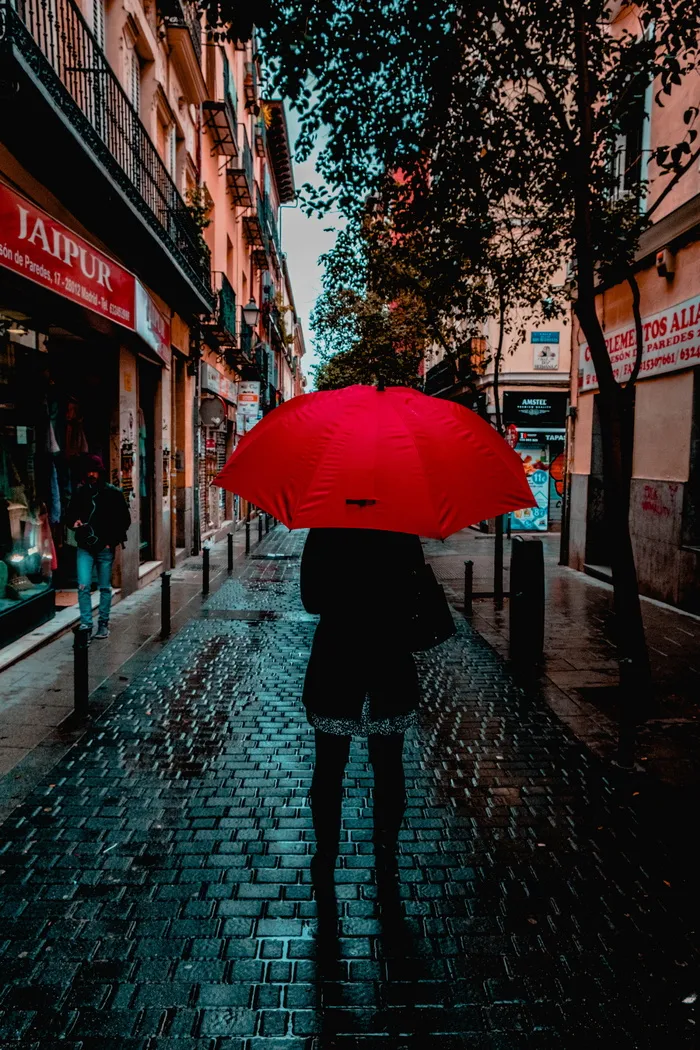 持红色雨伞者照片