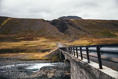 一座横跨淡水河的桥,周围是长满青苔的山脉 一座横跨淡水河的桥,周围是长满青苔的山脉