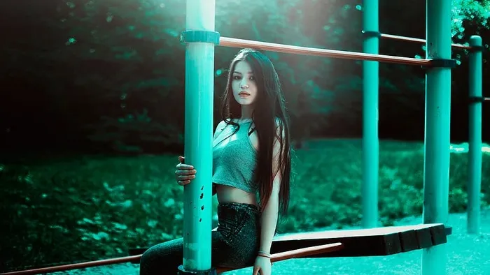 穿着灰色短上衣坐在棕色杆子上的女人