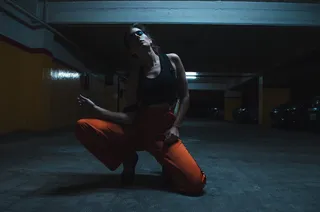 穿着背心跪在地板上的女人