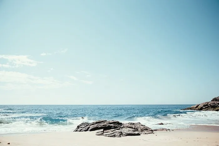 阳光下的岩石海滩，背景是地平线