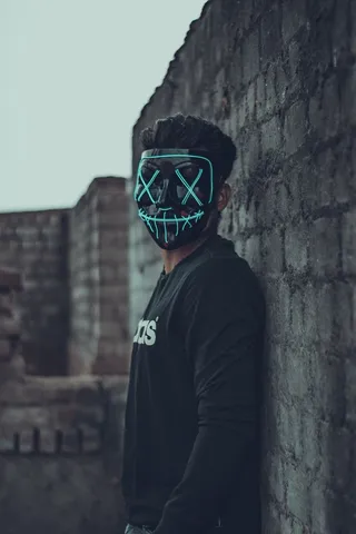 戴口罩的男子靠在墙上