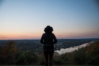站在草地上看黄金时刻的女人