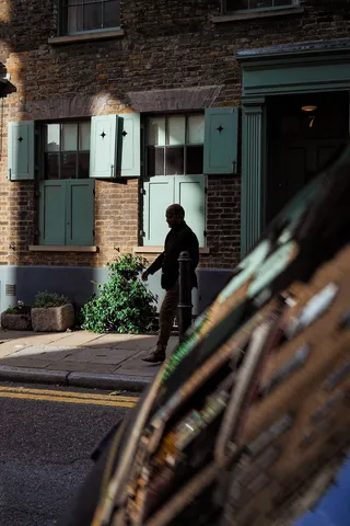 站在棕色混凝土建筑附近的人的剪影