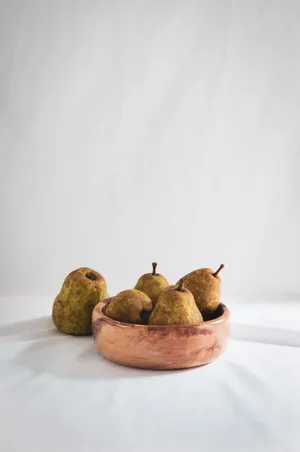 棕色木碗上的五个梨