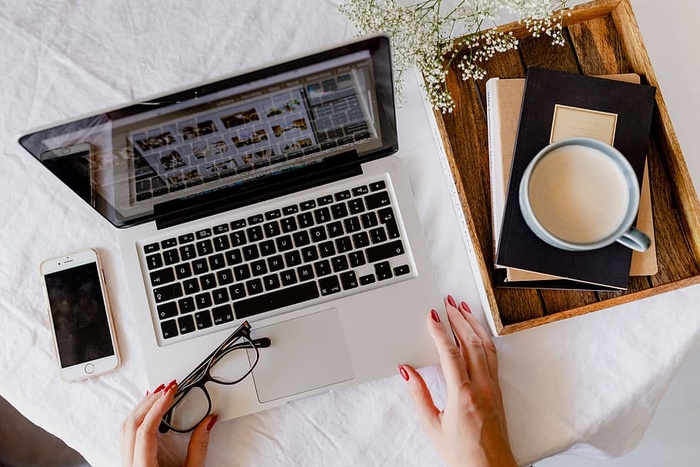 一位女士在一张桌子旁工作，桌上有一台笔记本电脑和一杯咖啡