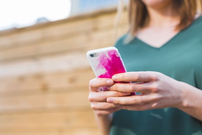 在户外使用Iphone的女性