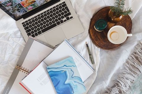 床上放满了枕头和带苹果小玩意的笔记本