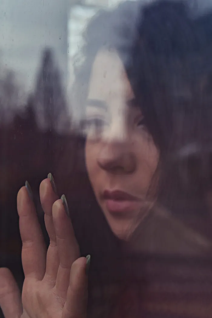 女人触摸窗户的浅焦照片