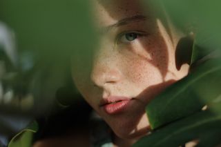 躲在绿叶后面的女人的特写照片