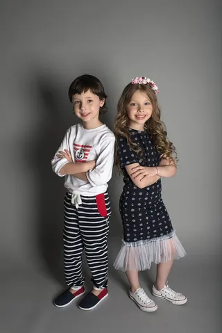 两个男孩和女孩穿着衣服站着