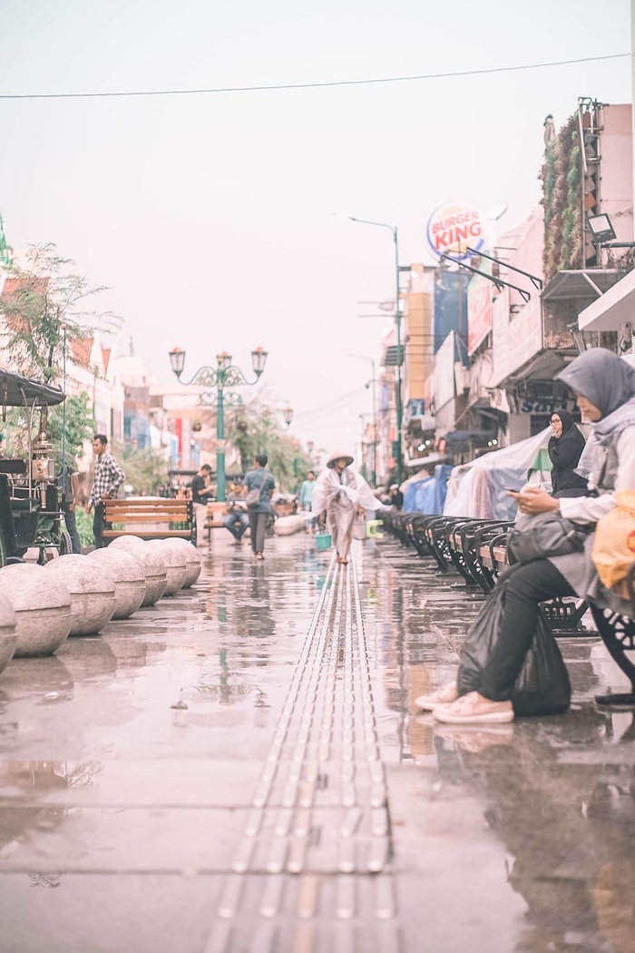 白天坐在户外黑色长椅上的人