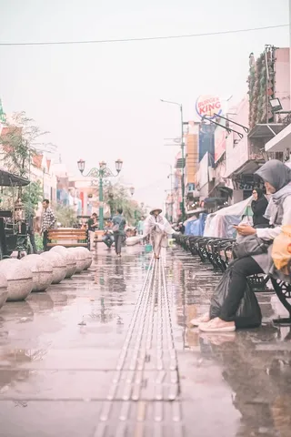 白天坐在户外黑色长椅上的人