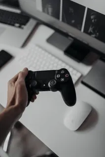 持有索尼PlayStation Dualshock 4控制器的人 持有索尼PlayStation Dualshock 4控制器的人