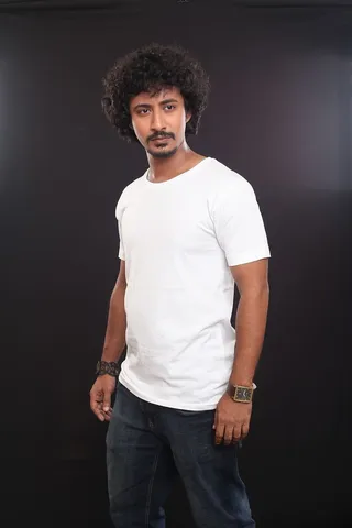 身穿白色圆领衬衫和黑色牛仔裤的男子