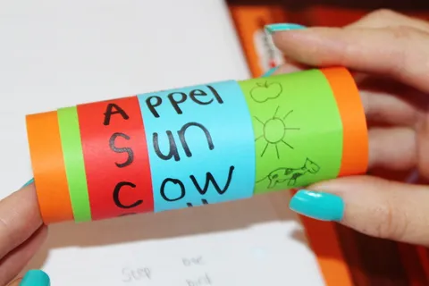 person、holding、teal、green、tube、read、learn、letters