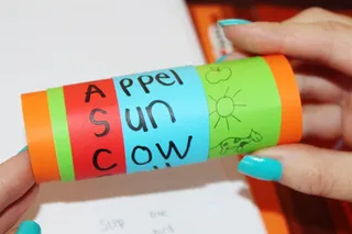 person、holding、teal、green、tube、read、learn、letters