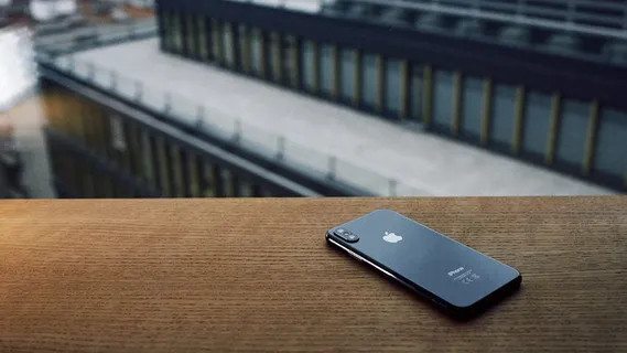 棕色木桌上太空灰色iPhone X的聚焦照片 棕色木桌上太空灰色iPhone X的聚焦照片