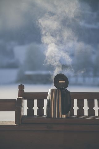 木制长凳上的灰色和黑色电热壶