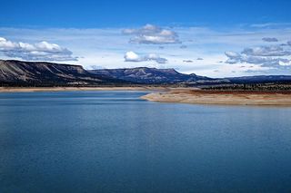 新墨西哥州的El Vado湖在蓝天下非常蓝。远处可以看到散落的云。查马和苍鹭湖就在附近。