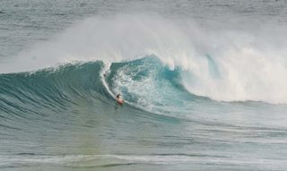 白天用橙色冲浪板冲浪的人