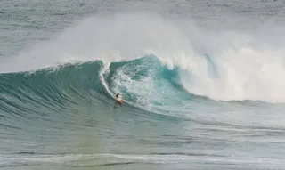 白天用橙色冲浪板冲浪的人