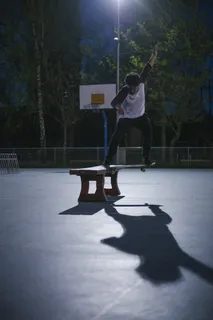 男子在板凳上做滑板特技 男子在板凳上做滑板特技