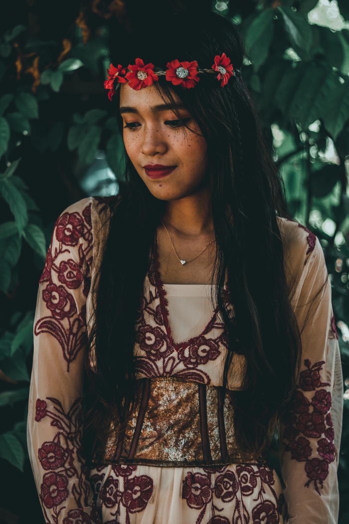 身着花卉连衣裙的女子站着的照片。