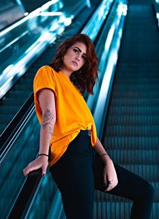 自动扶梯上穿着黄色T恤的女性的选择性聚焦摄影