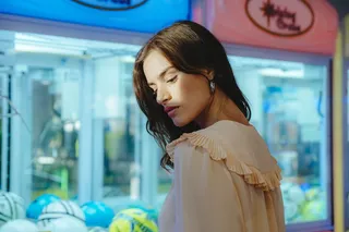 在街机旁穿着米色上衣的女人