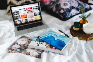 床上放满了枕头和带苹果小玩意的笔记本