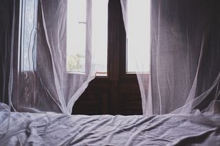 窗户旁的白色床罩