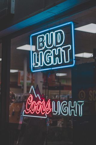 Coors Light 霓虹灯标牌上方的 Bud Light