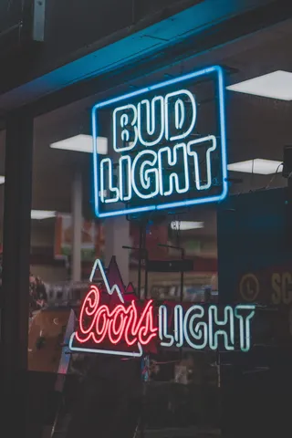Coors Light 霓虹灯标牌上方的 Bud Light