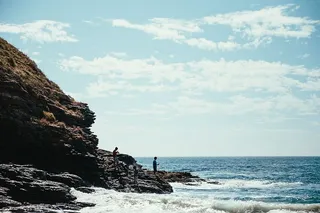 以地平线为背景的海边岩石徒步旅行者