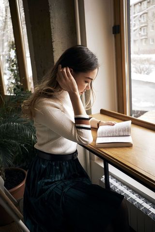 在窗前看书的女人