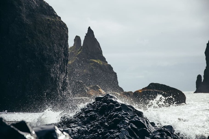 海水溅到海边的黑色火山岩上