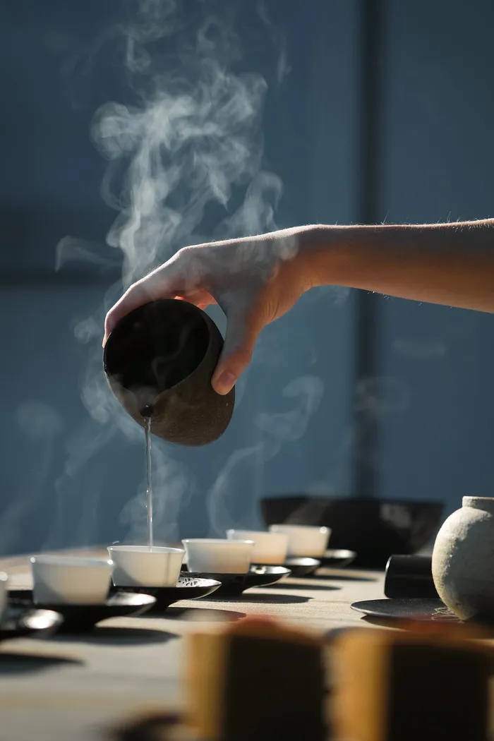 在白杯子上倒热水的人